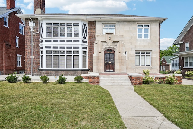 view of front facade featuring a front yard, brick siding, and a chimney