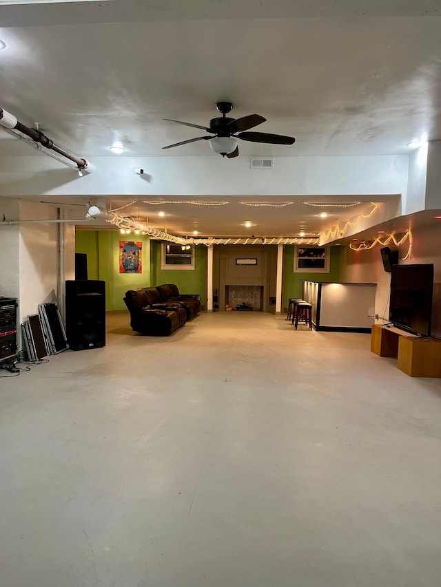 below grade area with a ceiling fan and a fireplace