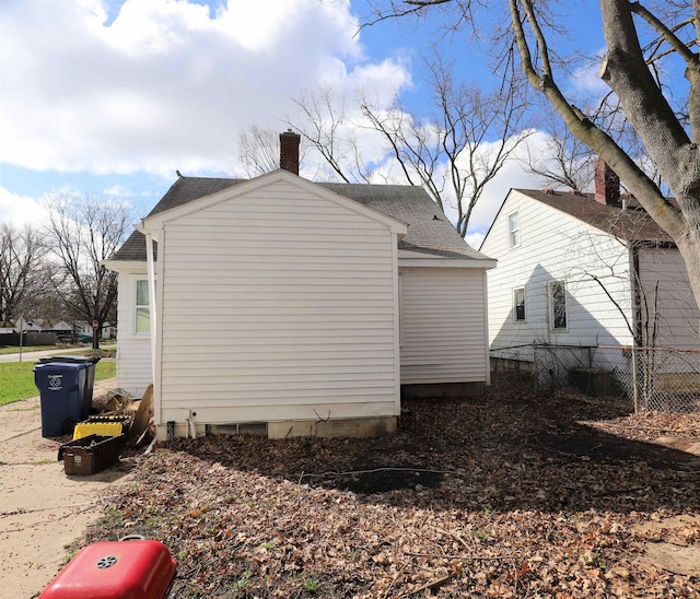 1406 Lincoln Ave, Flint, MI 48507 - view of side of property with a chimney, a shingled roof, and fence