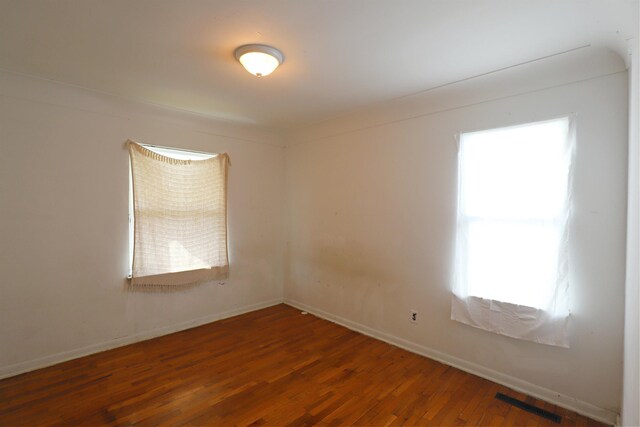 1406 Lincoln Ave, Flint, MI 48507 - spare room featuring wood finished floors, baseboards, and visible vents