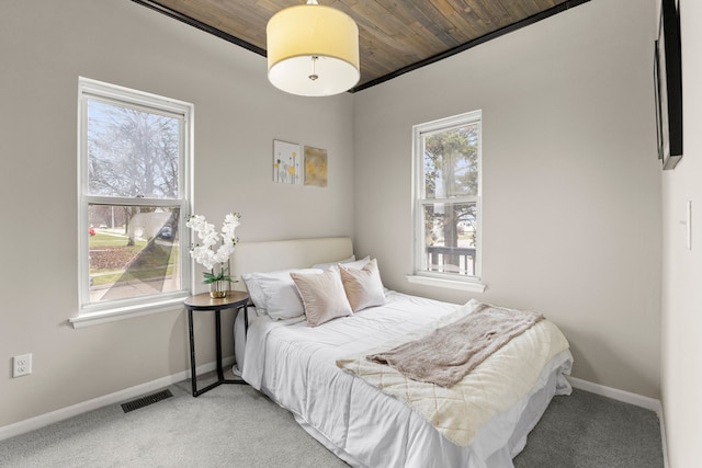 carpeted bedroom featuring wood ceiling, baseboards, and visible vents