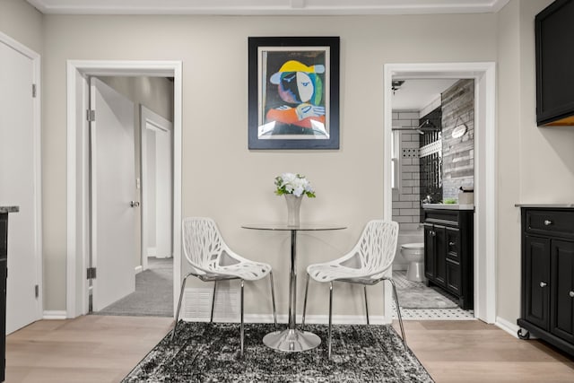 dining area with baseboards and light wood finished floors