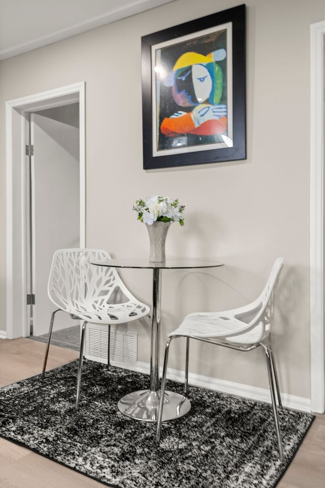 dining space with baseboards and wood finished floors