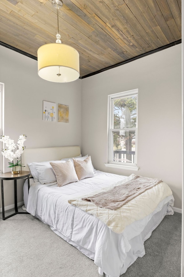 carpeted bedroom featuring wood ceiling and baseboards