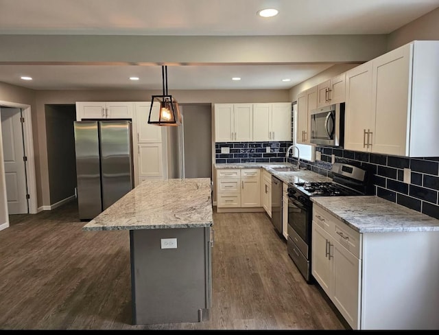 kitchen with white cabinetry, a center island, appliances with stainless steel finishes, light stone counters, and decorative backsplash