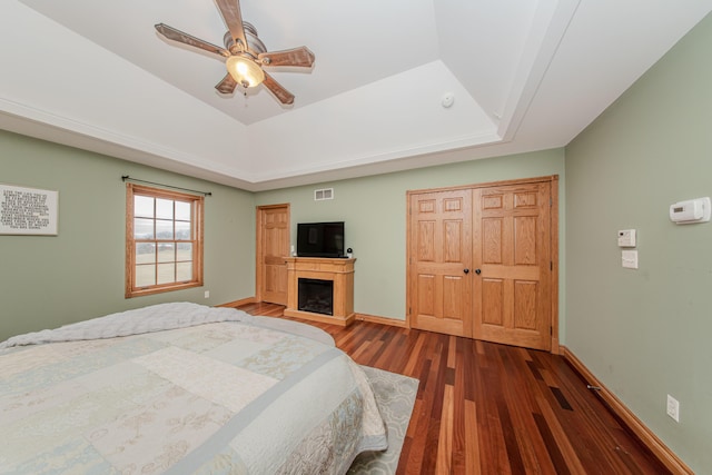 5050 Pleasant Lake Rd, Ann Arbor, MI 48103 - bedroom with a raised ceiling, wood finished floors, a fireplace, ceiling fan, and a closet