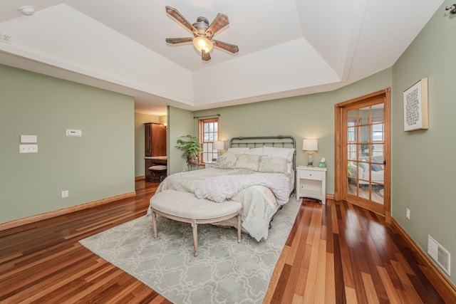 5050 Pleasant Lake Rd, Ann Arbor, MI 48103 - bedroom with a tray ceiling, wood finished floors, a ceiling fan, and connected bathroom