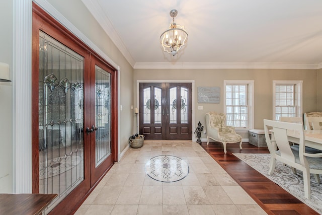 5050 Pleasant Lake Rd, Ann Arbor, MI 48103 - foyer entrance featuring french doors, a chandelier, ornamental molding, and tile patterned flooring