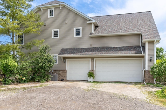 5050 Pleasant Lake Rd, Ann Arbor, MI 48103 - view of side of property with brick siding, driveway, roof with shingles, and a garage
