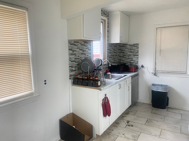 9619 Decatur St, Detroit, MI 48227 - kitchen featuring dishwasher, white cabinets, a sink, and tasteful backsplash