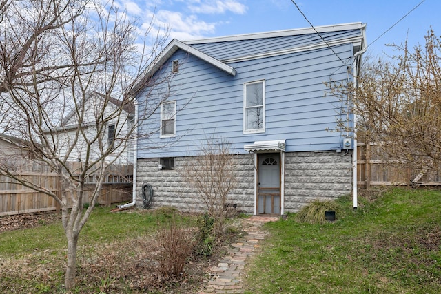 rear view of property with a yard and fence