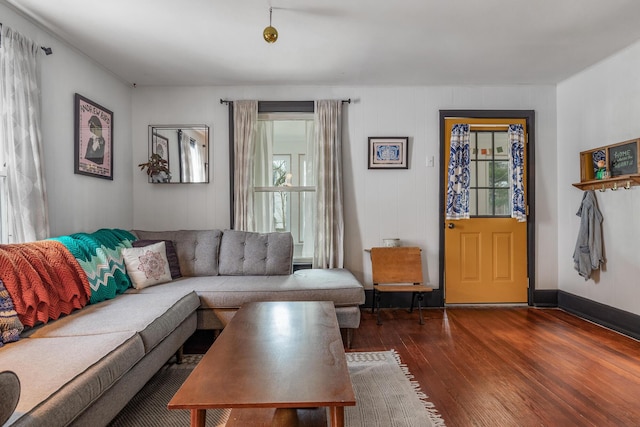 living room featuring baseboards, wood finished floors, and a healthy amount of sunlight