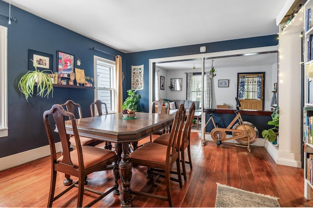 dining space with hardwood / wood-style floors and baseboards