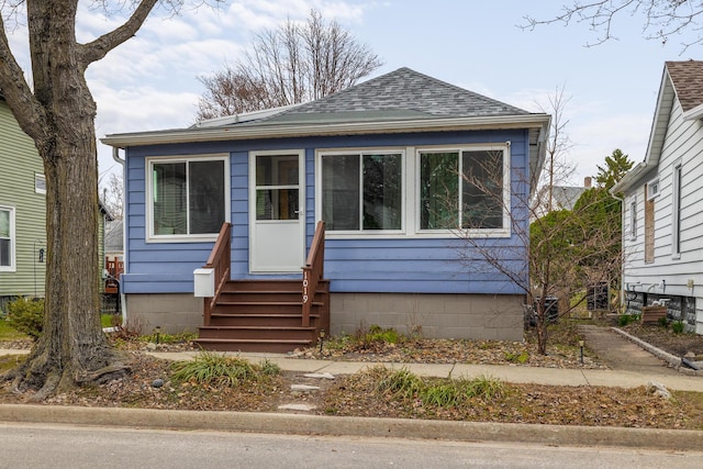 bungalow with a shingled roof and entry steps