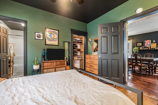 bedroom featuring a closet, lofted ceiling, ensuite bath, ceiling fan, and hardwood / wood-style floors