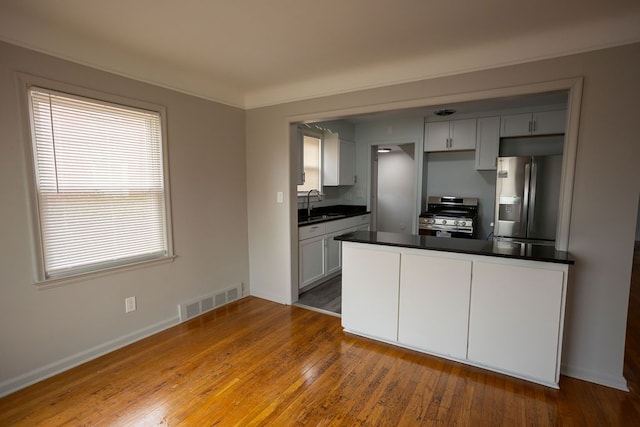 15655 Ego Ave, Eastpointe, MI 48021 - kitchen featuring visible vents, a sink, dark countertops, hardwood / wood-style flooring, and stainless steel appliances
