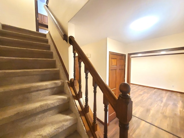 stairs featuring wood finished floors