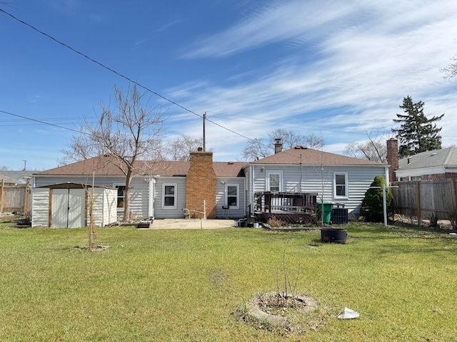 24275 Valley Ave, Eastpointe, MI 48021 - back of property with a storage shed, a wooden deck, a patio area, and a chimney