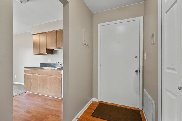 entryway with baseboards, visible vents, and light wood-style flooring
