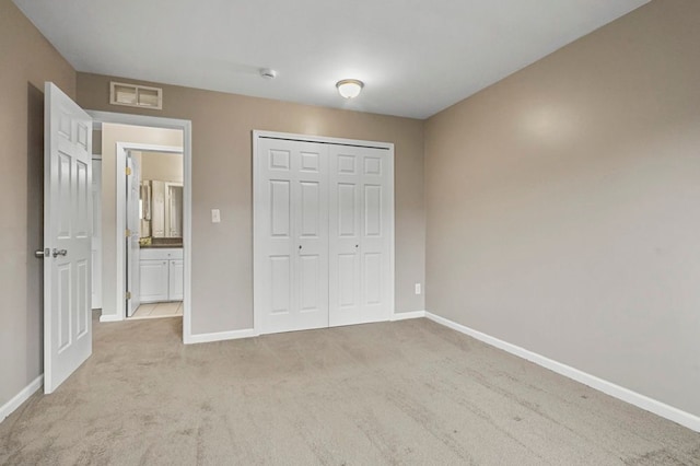 unfurnished bedroom featuring baseboards, carpet flooring, visible vents, and a closet
