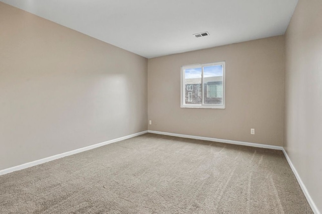 carpeted empty room featuring baseboards and visible vents
