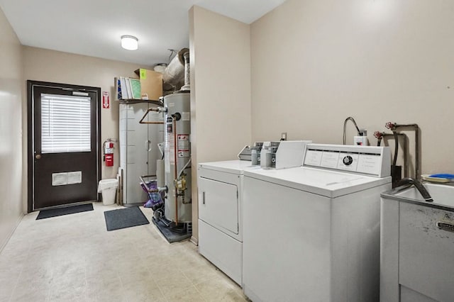washroom with water heater, separate washer and dryer, and light floors
