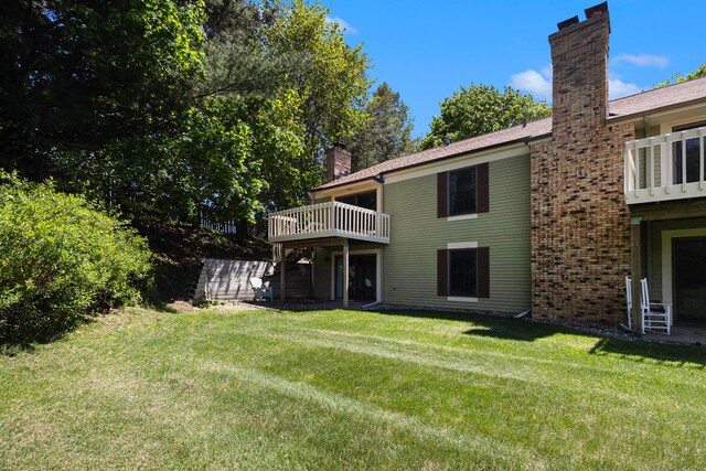 17650 Woodbridge Rd # 1, Spring Lake, MI 49456 - back of house featuring a chimney, a lawn, a wooden deck, and brick siding