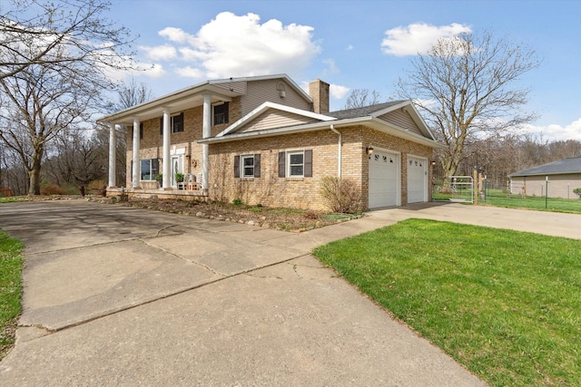 greek revival house with a porch, an attached garage, a chimney, concrete driveway, and brick siding