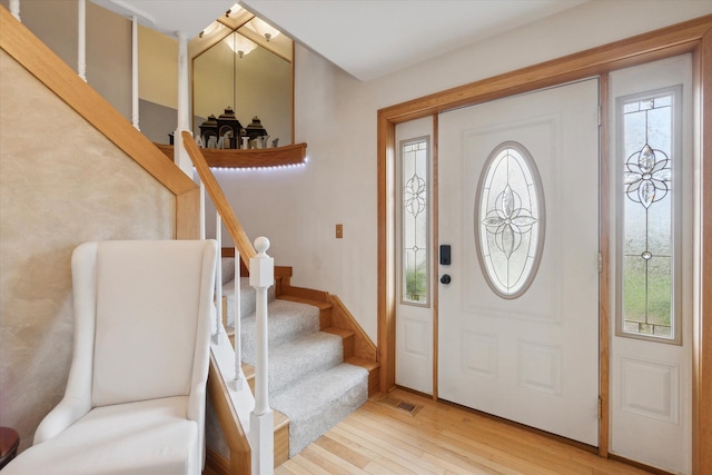 entrance foyer with light wood-type flooring, visible vents, and stairway