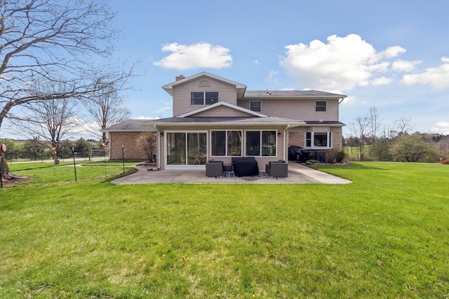 rear view of property with a sunroom, a yard, fence, a patio, and brick siding