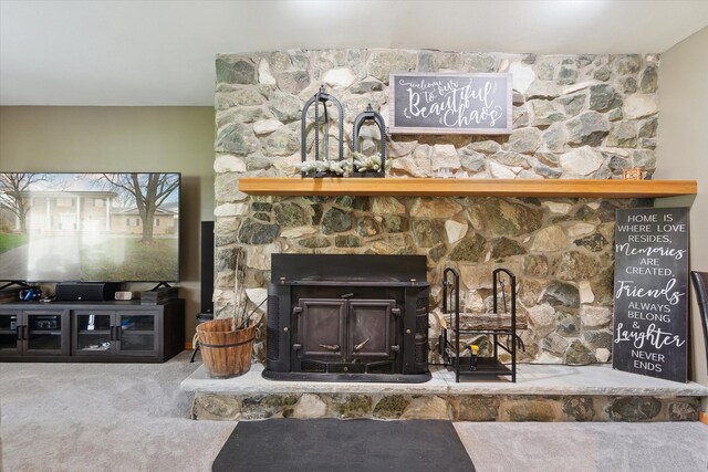 details with a stone fireplace and carpet