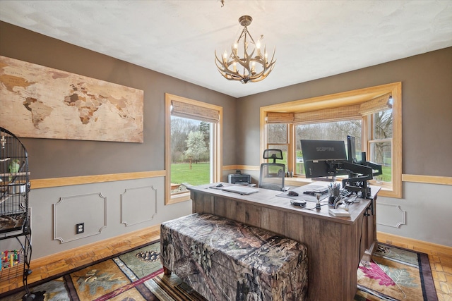 office area with a chandelier and wainscoting