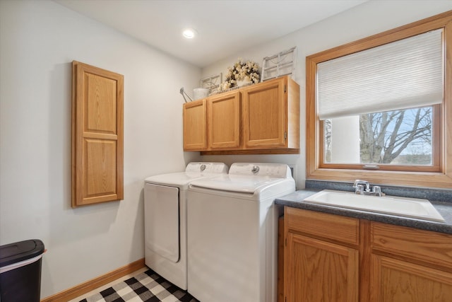 laundry area with baseboards, recessed lighting, cabinet space, washer and dryer, and a sink