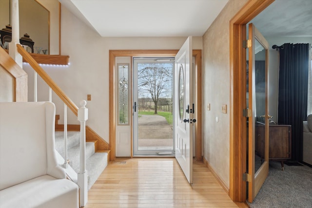foyer with stairs and light wood finished floors