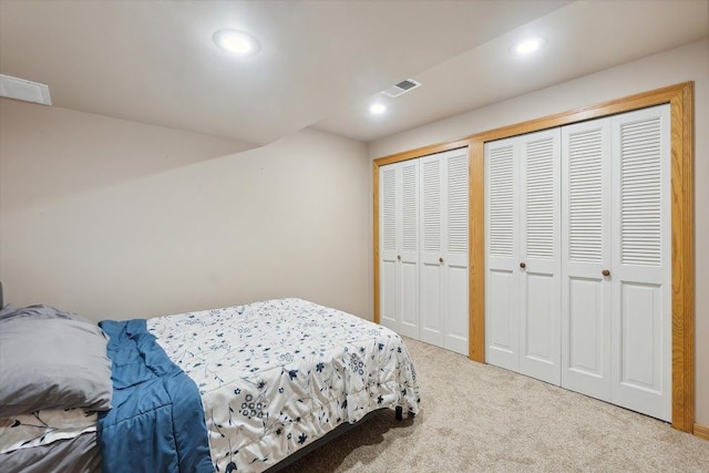 bedroom with carpet floors, recessed lighting, visible vents, and multiple closets