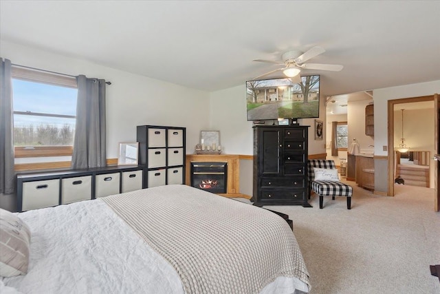 bedroom with a glass covered fireplace and carpet