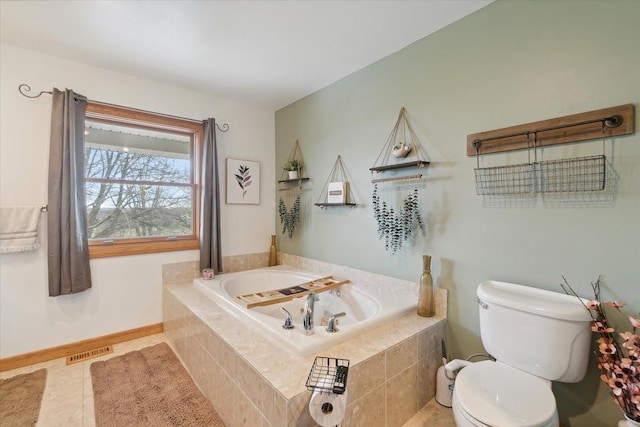 bathroom featuring baseboards, tile patterned flooring, toilet, visible vents, and a garden tub