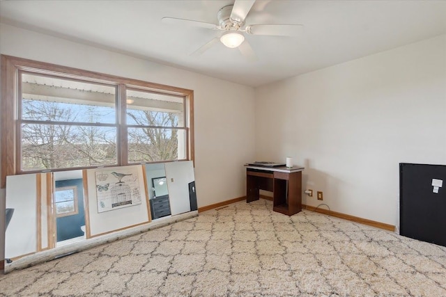 carpeted empty room with ceiling fan and baseboards