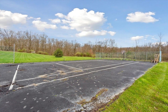 uncovered parking lot featuring community basketball court and fence