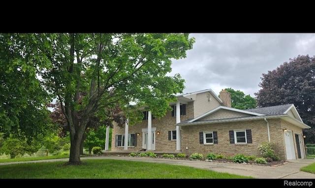 8114 Gale Rd, Goodrich, MI 48438 - view of front of home with a garage, brick siding, and a chimney