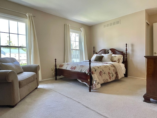 carpeted bedroom featuring baseboards and visible vents