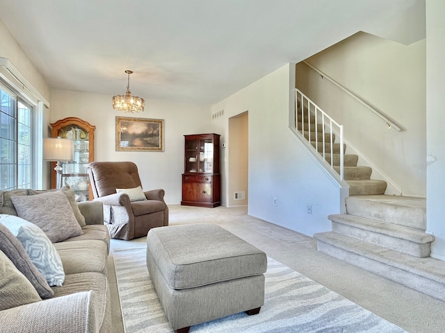 living room with stairs, an inviting chandelier, light colored carpet, and visible vents