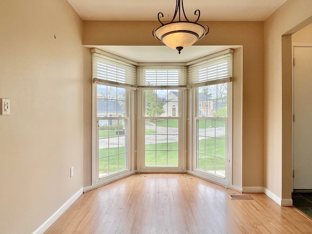 empty room with visible vents, baseboards, and light wood-style floors