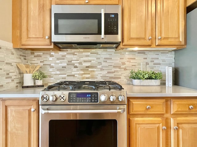kitchen featuring appliances with stainless steel finishes, tasteful backsplash, and light countertops