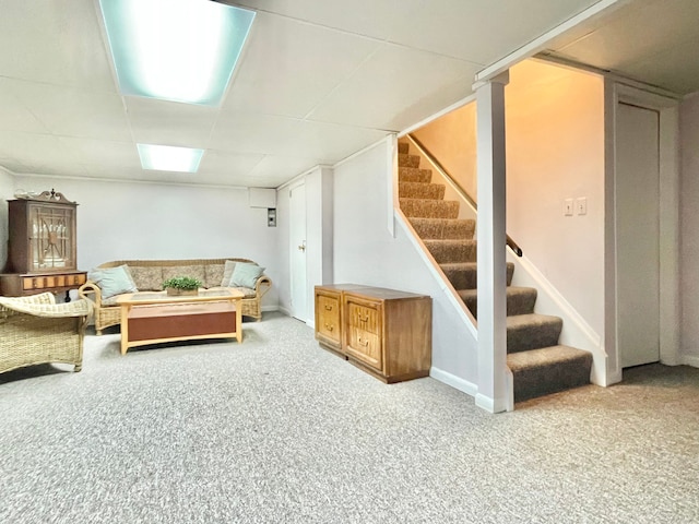 carpeted living room featuring stairs and a paneled ceiling