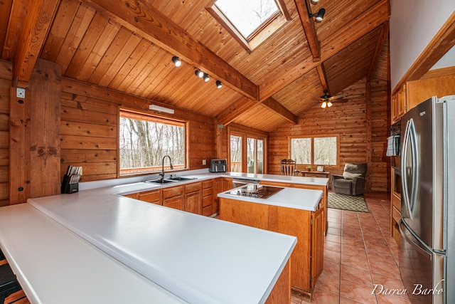 3770 Pine Ln, Saranac, MI 48881 - kitchen featuring freestanding refrigerator, a peninsula, a wood ceiling with exposed beams, a skylight, and light countertops