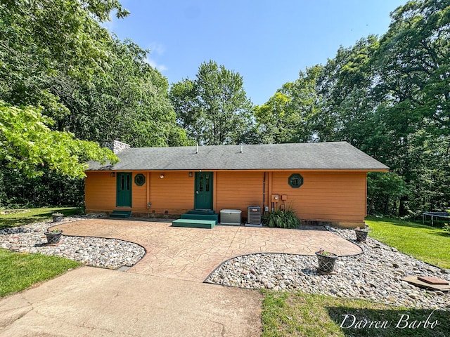3770 Pine Ln, Saranac, MI 48881 - rear view of house with a trampoline, entry steps, a patio, a lawn, and a chimney