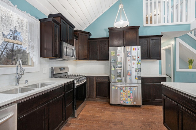 kitchen featuring a sink, light countertops, appliances with stainless steel finishes, and dark wood-style flooring