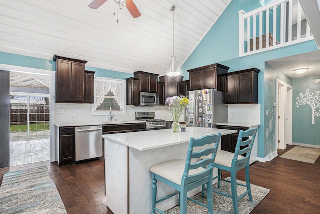 kitchen with dark brown cabinets, a sink, stainless steel appliances, and dark wood-style floors