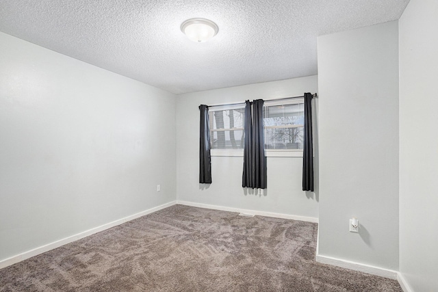 carpeted empty room with baseboards and a textured ceiling